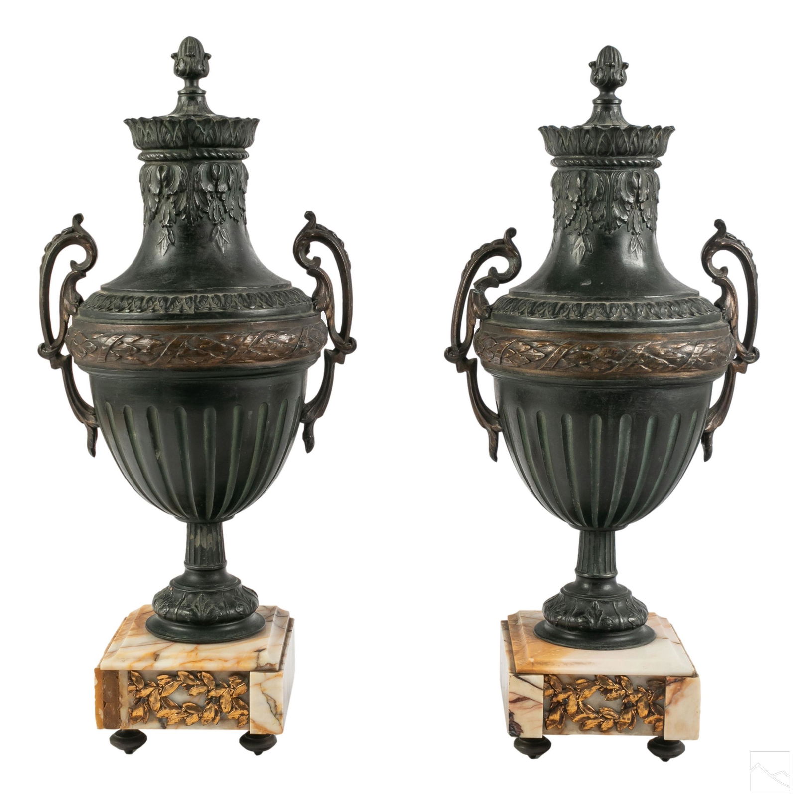 Neoclassical French Antique Metal Garniture Urns: Pair of Neoclassical style patinated white metal garnitures. Oversized metal urns having sprig handles, oak leaf motifs, acorn finials and high relief decorations to the body. Resting on marble mounts