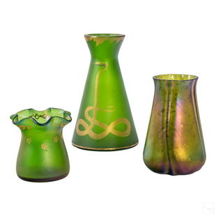 Loetz Style Studio Art Glass Iridescent Vases LOT: Group of three Loetz style studio art glass vases. Lot includes (1) ruffled lip vase with floral gold gilt accents measuring 3.5" x 3.5" x 3.5"; (1) beaker formed iridescent vase measuring 5.5" x 4"