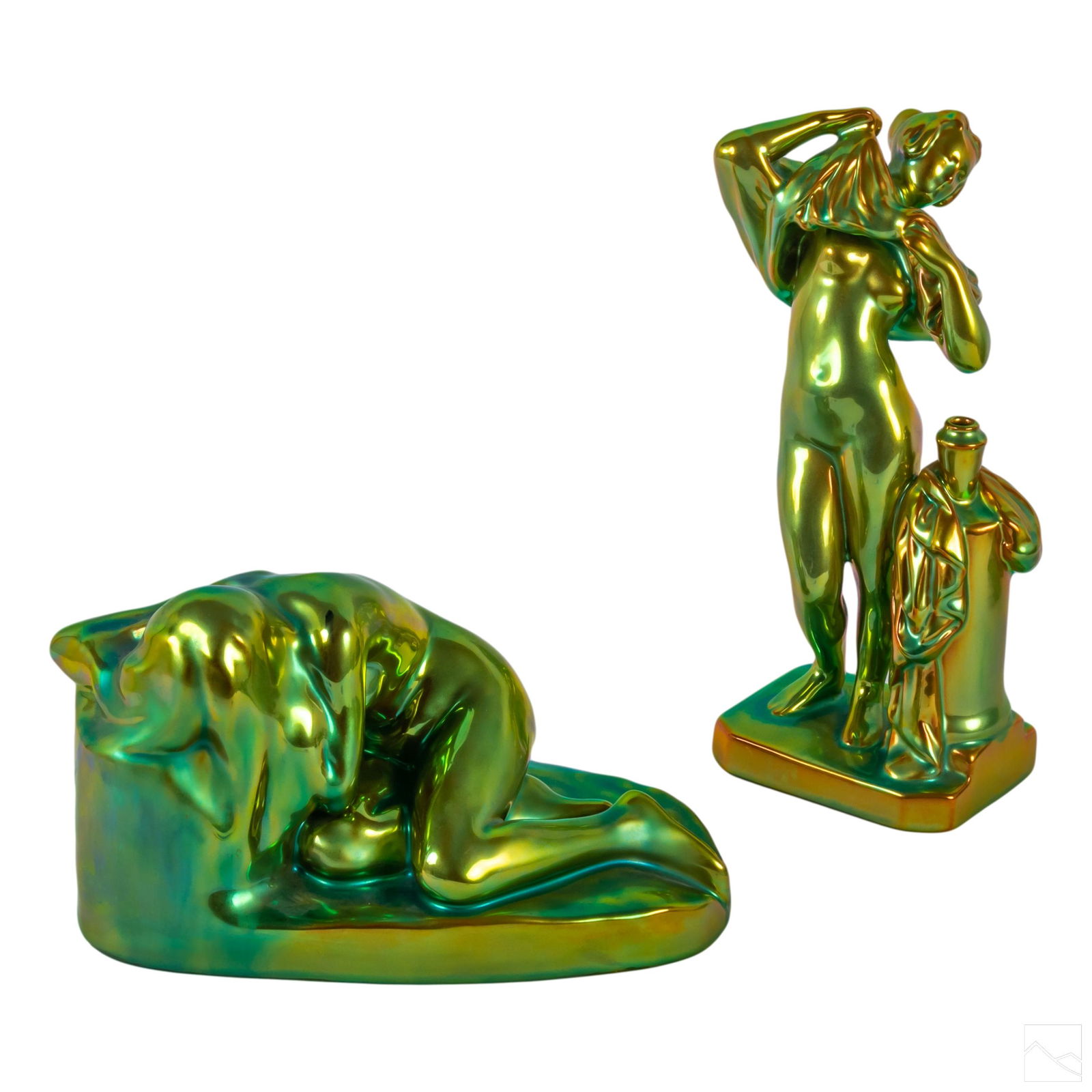 Zsolnay Green Eosin Porcelain Nude Women Figurines: Lot of two iridescent green gold eosin Hungarian porcelain sculptures by Zsolnay. Lot features (1) nude woman measuring 5.5" x 11" x 5", and (1) woman undressing measuring 11" x 6.5" x 3". Both marked