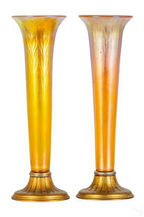 Louis Tiffany PAIR Favrile Art Glass Trumpet Vases: Louis Comfort Tiffany (American, 1848-1933) Early 20th century pair of LCT golden iridescent Favrile art glass trumpet vases. Bronze base accented with red enamel. Impressed makers mark on bottom,