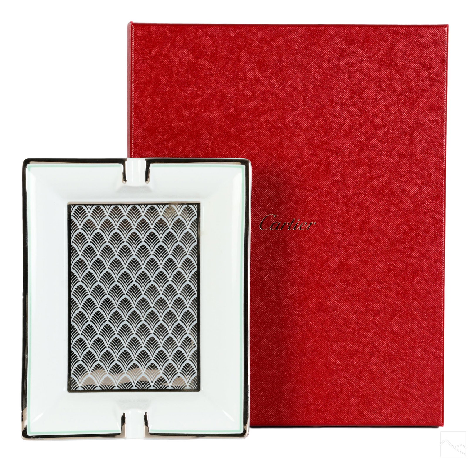 Cartier French Limoges Porcelain Tobacco Ashtray: A Cartier French porcelain ashtray. Art Deco design in white, silver, and mint green with overlapping silver shells on a white background. Bordered in silver and mint green. Signed CARTIER in front si