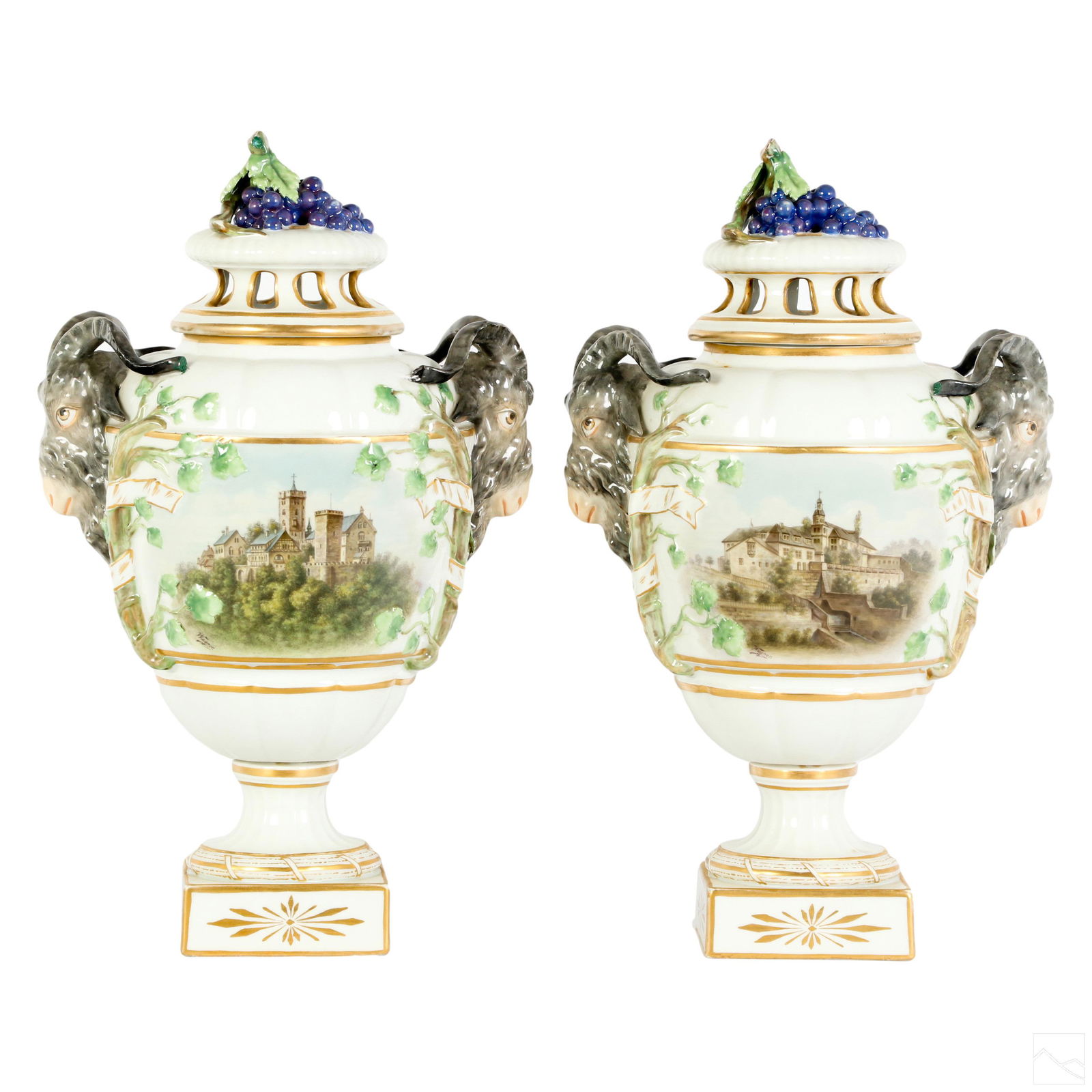KPM German Pair Porcelain Rams Head Landscape Urns: A pair of KPM German porcelain lidded urns. White bulbous bodies with hand painted architectural landscape scene with church and other buildings to one side. Signed WAGNER. Opposite sides having still