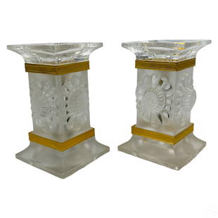 Lalique Crystal Pair Paquerettes Deco Candlesticks: A pair of Lalique French crystal candlesticks in the Paquerettes ("daisies") pattern. Rectangular pedestal form bodies with horizontal gilt metal banded decorations to top and bottom of surrounding re