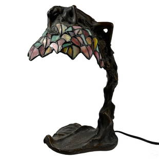 E Thomasson Nouveau Bronze Glass Daphne Table Lamp: E Thomasson stained glass lamp. A figural work depicting the Greek nymph, Daphne, transforming into a bay laurel tree to evade the desires of Apollo. Striking bronze tree form landscape base with gorg