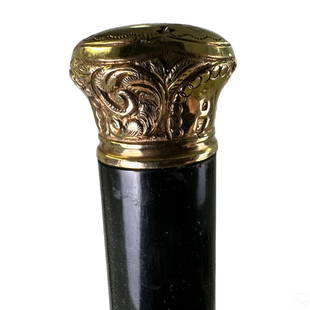 Gold Topped 19C. Victorian Wood Cane Walking Stick: An antique 19th Century gentleman's walking stick cane. Black enameled wood in an elegant tapered design capped with an ornate gold top with encircling raised relief scrolling and feathered designs to