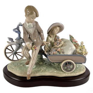 Lladro Spanish Porcelain COUNTRY RIDE Statue #5958: A Lladro Spanish porcelain figurine. Titled, "Country Ride," model 5958. A figural group with young male and female figures with bicycle style wagon and a profusion of floral forms. LLADRO backstamp t