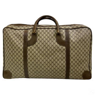 Gucci Italian Designer Travel Luggage Suitcase Bag: A vintage Gucci Italian designer suitcase bag. Large nylon fabric body with leather details and handles, and zippered top opening to a generous interior space. Manufacturer GG logo repeated across ext