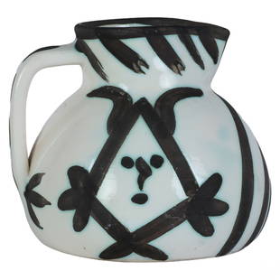 Pablo Picasso 1881-1973 Pichet Tetes 1953 Pitcher: Pablo Picasso (Spanish, 1881-1973). A limited edition Madoura studio art pottery vessel. Titled "Pichet Tetes." A white partially glazed earthenware pitcher with a black oxide devil face motif.