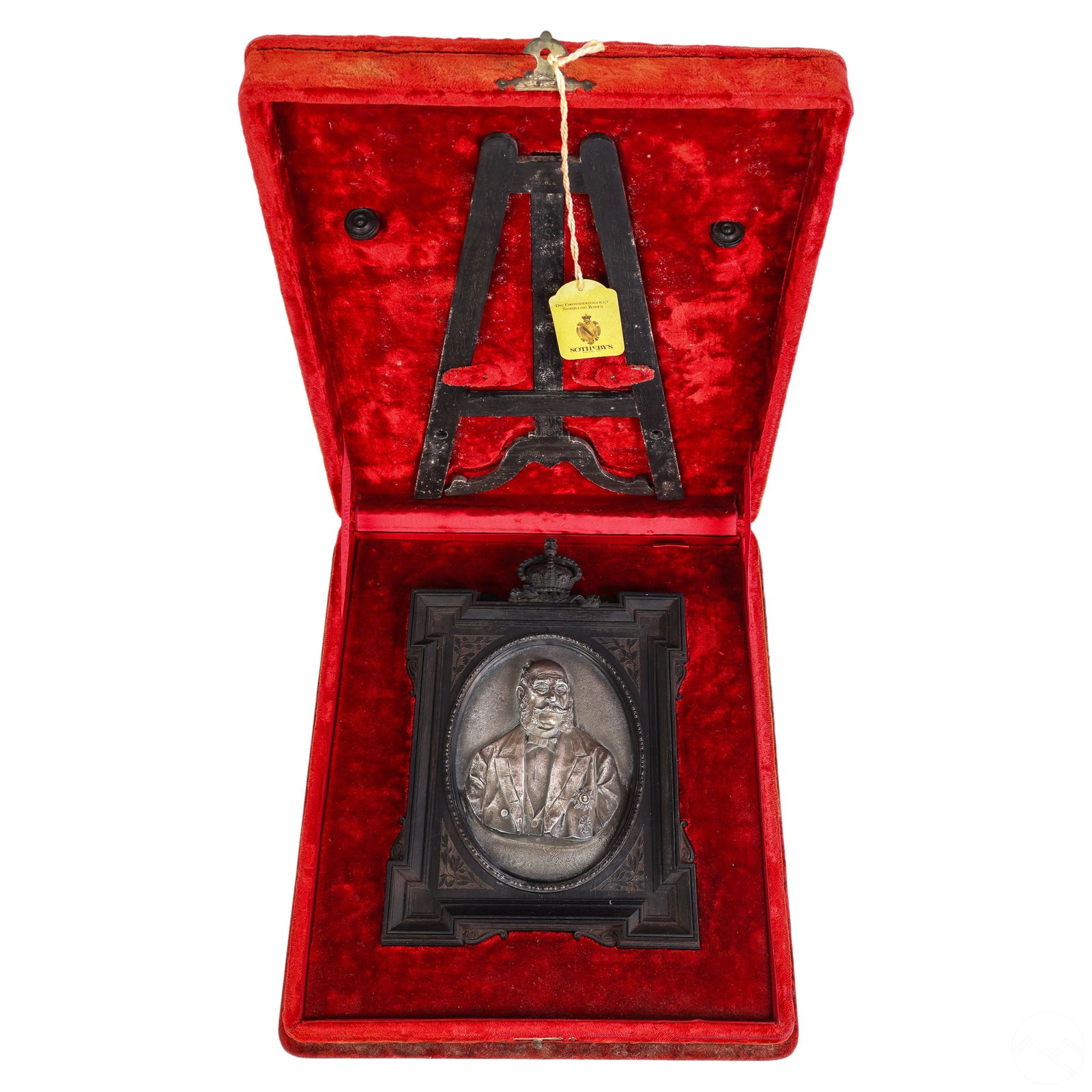 19C Silver Relief Portrait in Box w/ Sotheby's Tag: A Victorian antique portrait in high relief of a royal distinguished gentleman. Encased in an ornate carved Jet picture frame showcasing an intricate crown finial detailing. Presented in a fitted red