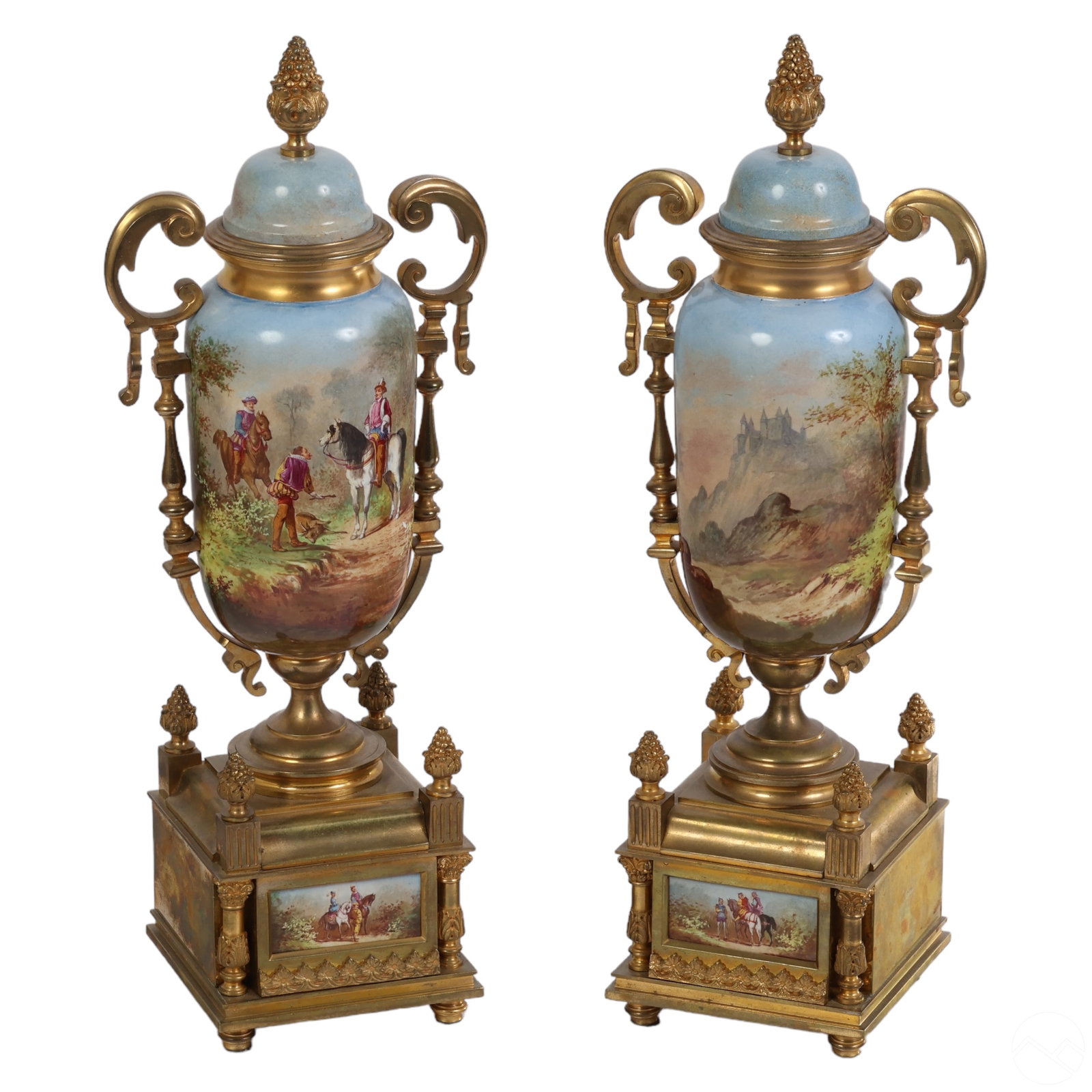 Sevres Pair Painted Porcelain & Bronze Garnitures: A pair of Sevres-style French porcelain garniture style urns with bronze mountings. They feature oblong glazed porcelain amphora forms richly hand-painted with figural landscape scenes depicting Frenc