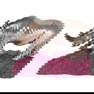 Asprey & Co of London Silver Model of a Rhino with Ruby Base: A finely crafted Wild Rhinoceros figurine by Asprey & Co. of London, set atop a natural Myanmar fluorescent ruby base. The rhino, made from solid silver, is meticulously detailed, capturing the