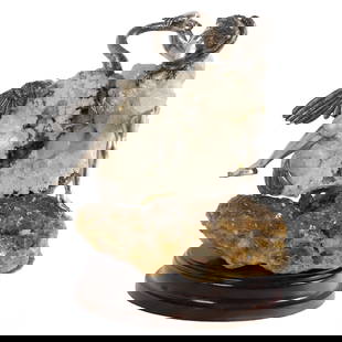 Carrera y Carrera Quartz Silver 'Woman Intertwined w/ Swan' Sculpture: This exquisite sculpture by the Spanish brand Carrera y Carrera showcases a detailed silver figure of a woman intertwined with a swan. The piece is artistically set atop a striking natural quartz