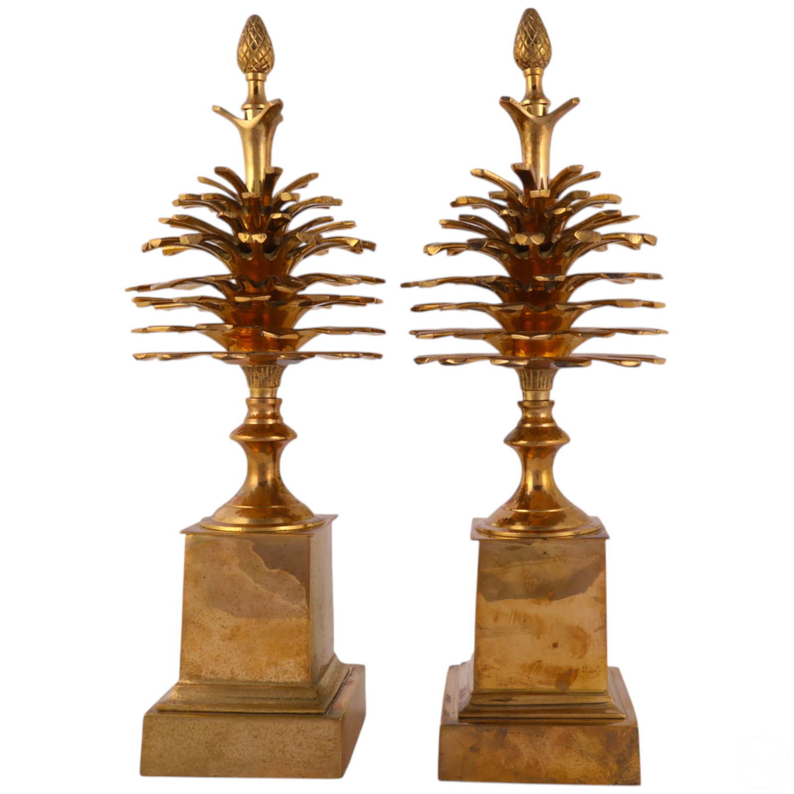 Mottahedeh Pinecone Garniture Maison Charles Style: Pair of Mottahedeh vintage brass pinecone garnitures in the manner of Maison Charles, produced in the 1970s. Each garniture features a detailed, weighty pinecone atop a square stepped brass base, crow