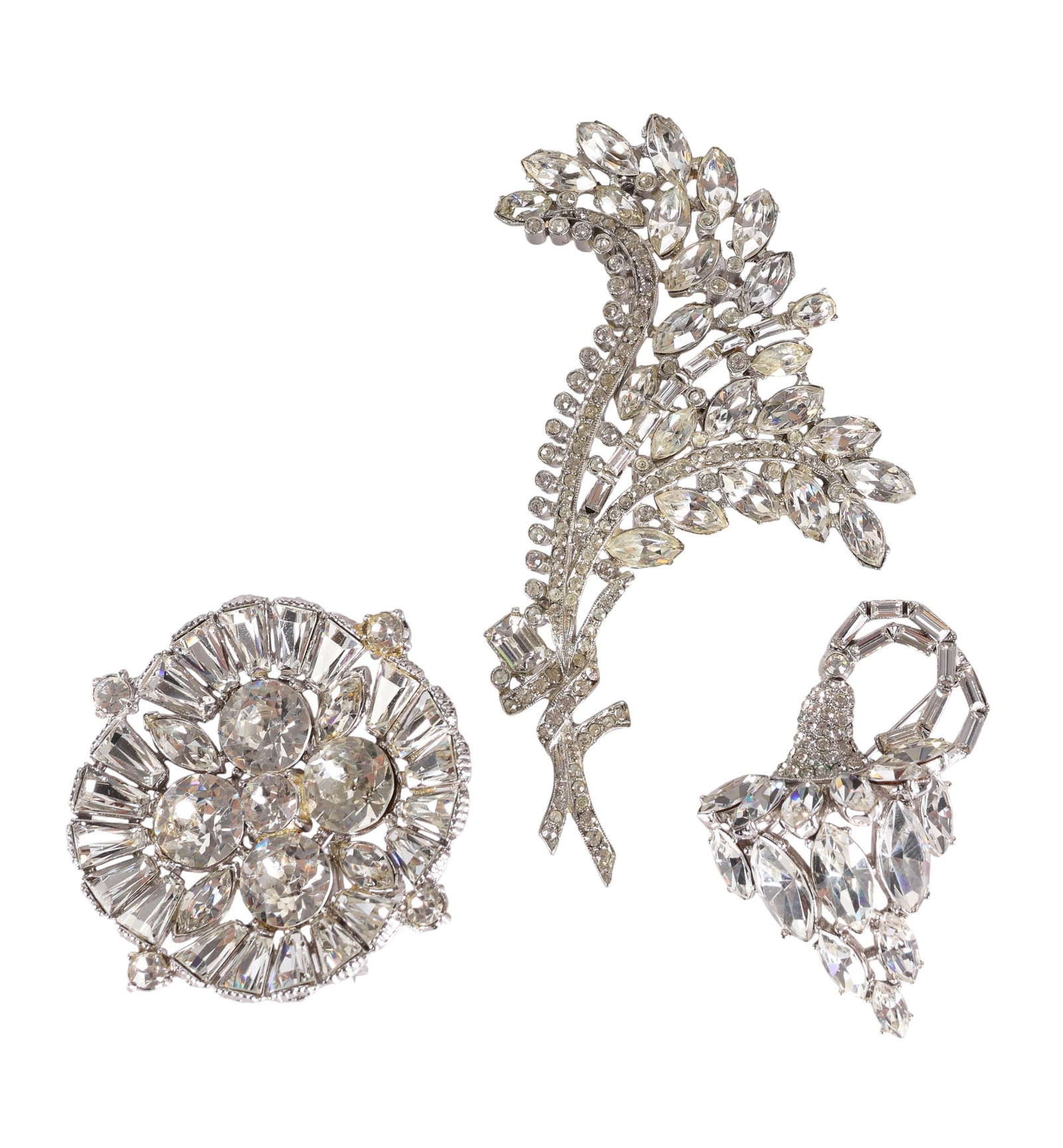 50s Rhodium Crystal Brooches Including ORA Signed: A group of three vintage rhodium-plated crystal brooches, circa 1950s. The first is a large gathered bouquet design set with marquise and round-cut clear crystals, measuring approximately 4" long by 2