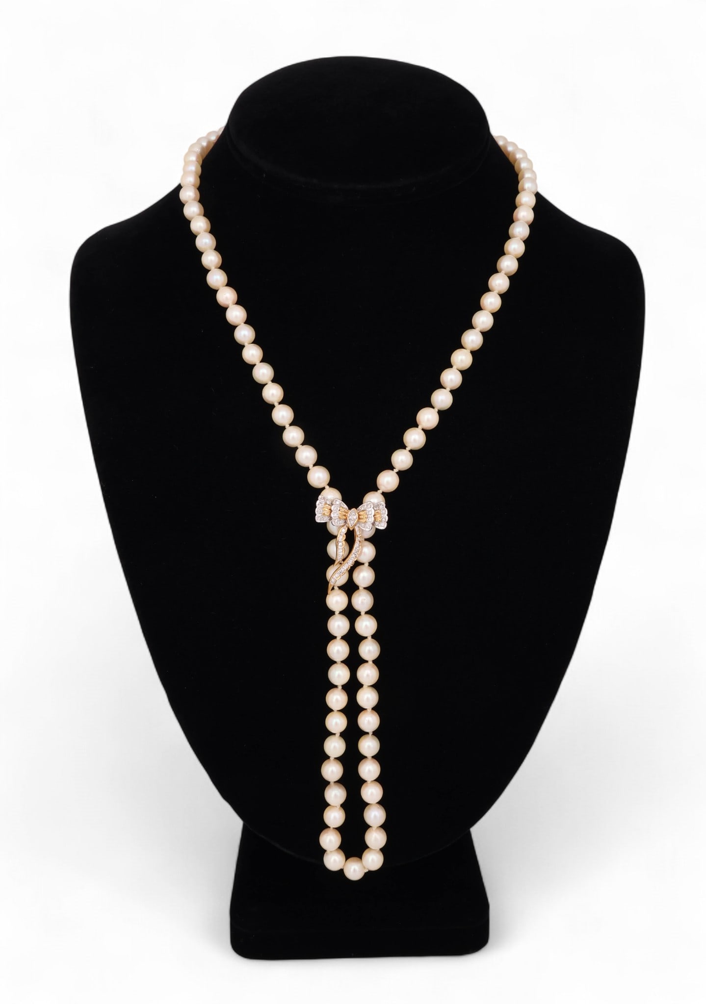 14k Gold .25 CT TW Diamond Bow 6mm Pearl Necklace: Cultured pearl necklace with diamond-accented enhancer pendant. The design features round white saltwater cultured pearls ranging from approximately 6.0 mm to 6.5 mm, each exhibiting fair luster and g