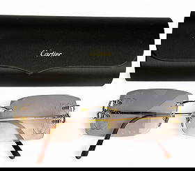 Cartier French Designer Eyeglass Sunglass Frames: Pair of Cartier France luxury designer rimless eyewear featuring gold-tone wire temples. The frames are signed Cartier and include a black Cartier hard case with a gold logo. Glasses currently have pr