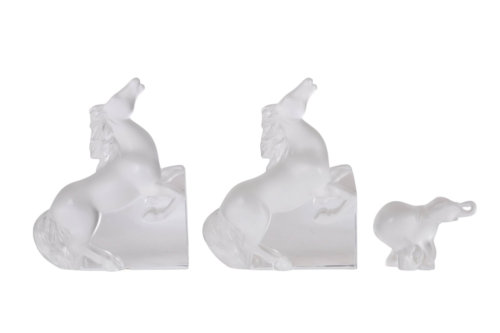 Lalique Kazak Horse Bookends and Elephant Figurine: Lalique French crystal group including a pair of Kazak bookends designed by Marie-Claude Lalique in 1996, featuring rearing horses, and an elephant figurine with a raised trunk. Each piece is signed L