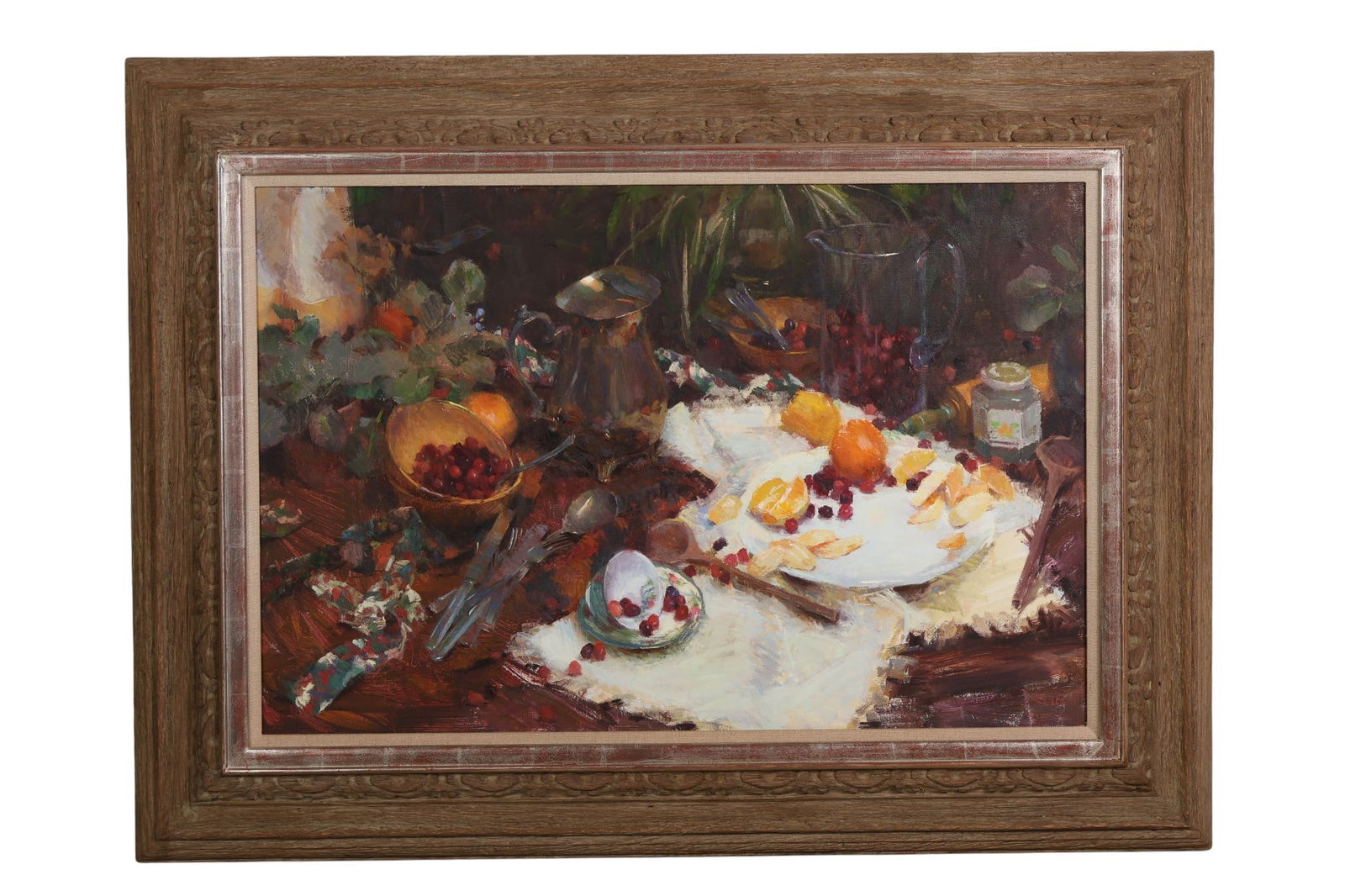 Nancy Guzik b.1954 Still Life with Fruit Painting: Nancy Guzik (American, born 1954), oil on canvas still life painting depicting a tabletop arrangement with citrus, cranberries, tableware, fabric, and foliage. Signed lower right. Presented in a carve