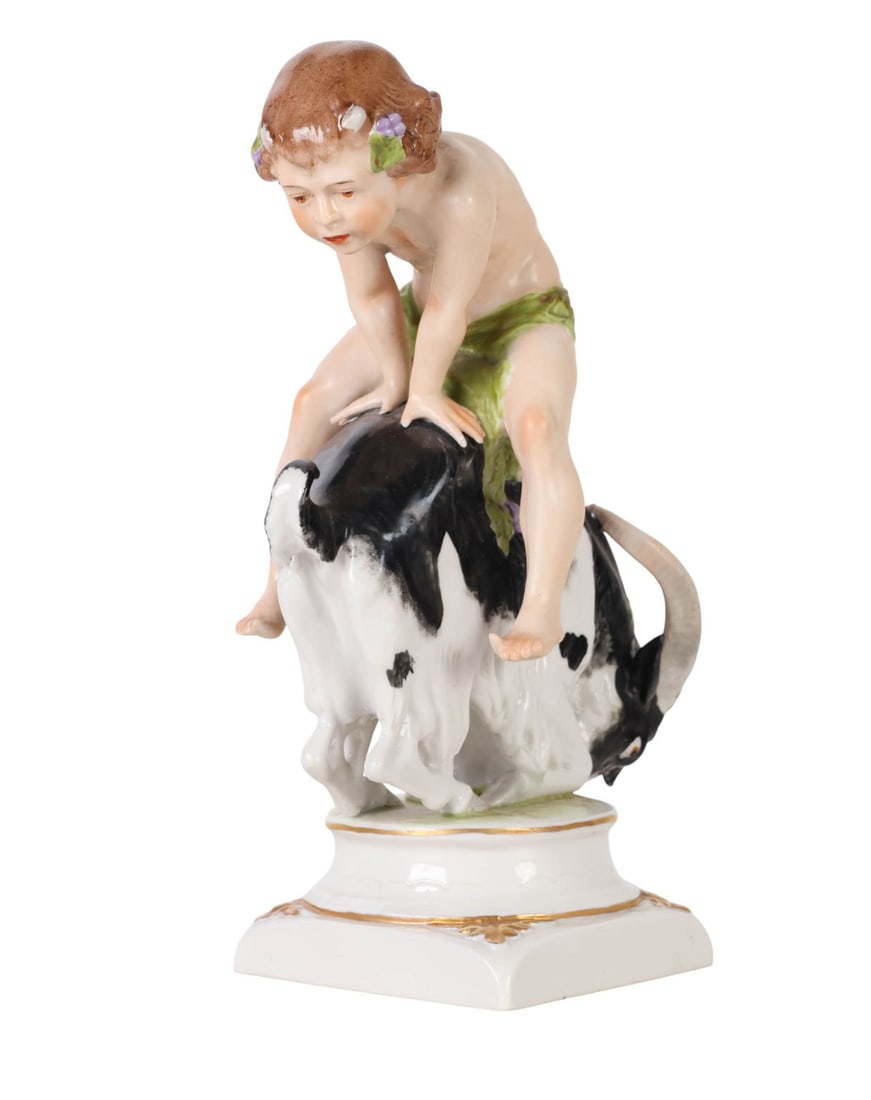 Kister Germany Porcelain Girl on Goat Figurine: Kister German porcelain figurine depicting a young child riding atop a spirited black-and-white goat. The figure is finely modeled with delicate hand-painted details, including floral accents, green