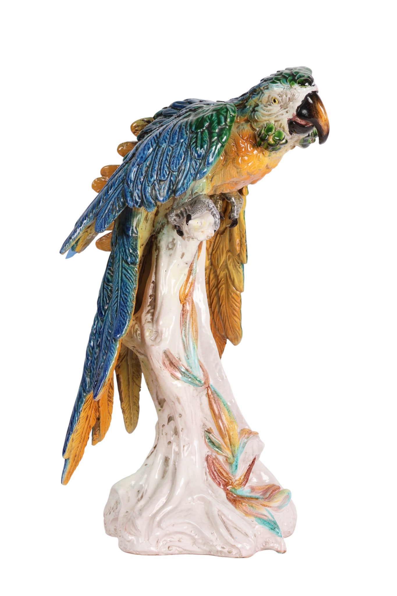 Italian Terracotta Pottery Perched Macaw Sculpture: Italian terracotta sculpture of a tropical blue parrot perched on a tree stump. The hand painted macaw features textured wings and a long tail extending downward, with one talon gripping a branch and