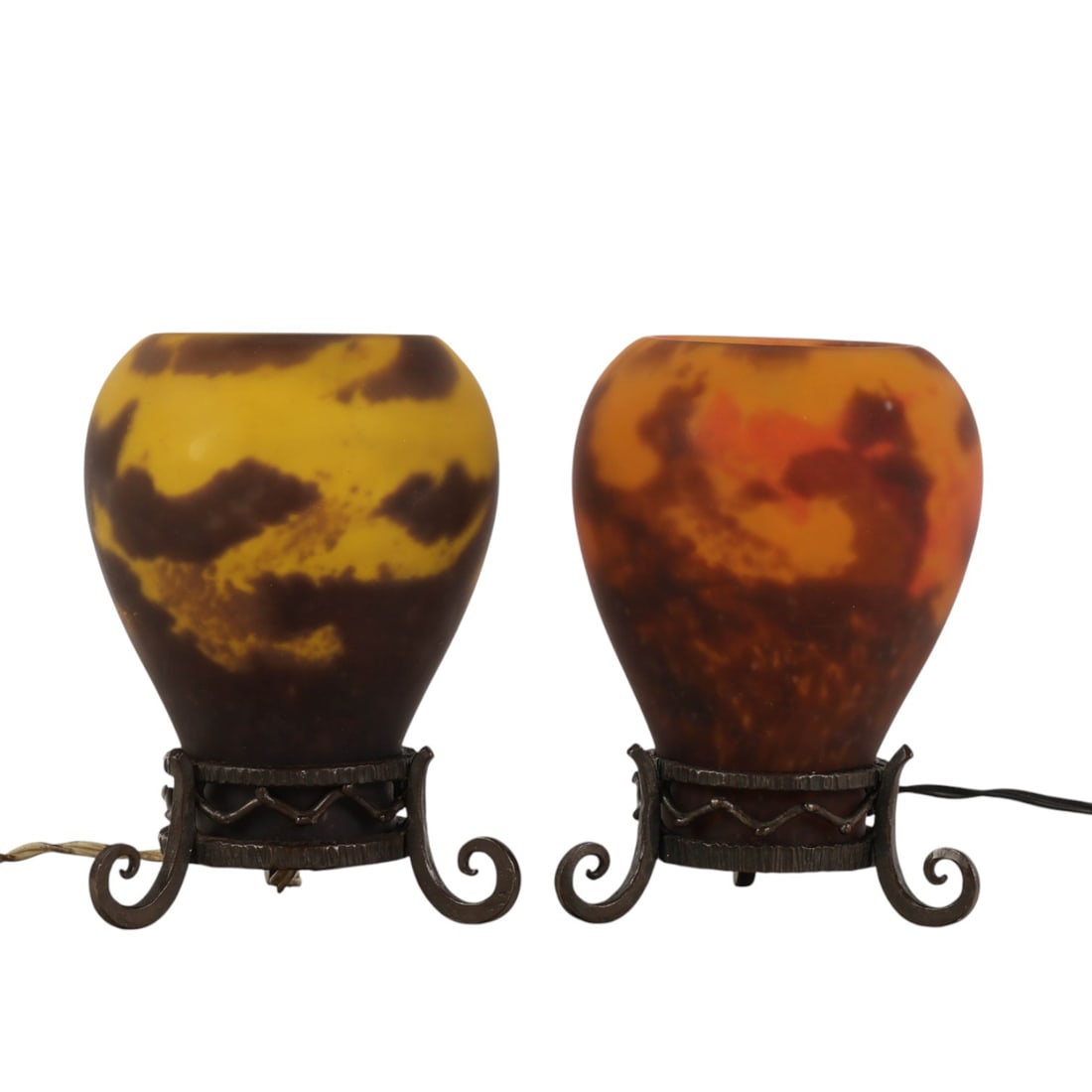 Robj Paris Art Deco Perfume Scent Glass Lamp LOT: Robj Paris lot of two art glass lamps. Each features mottled yellow and brown glass shades with integrated signatures near the base. Both rest on separate wrought metal stands with scrolled feet and
