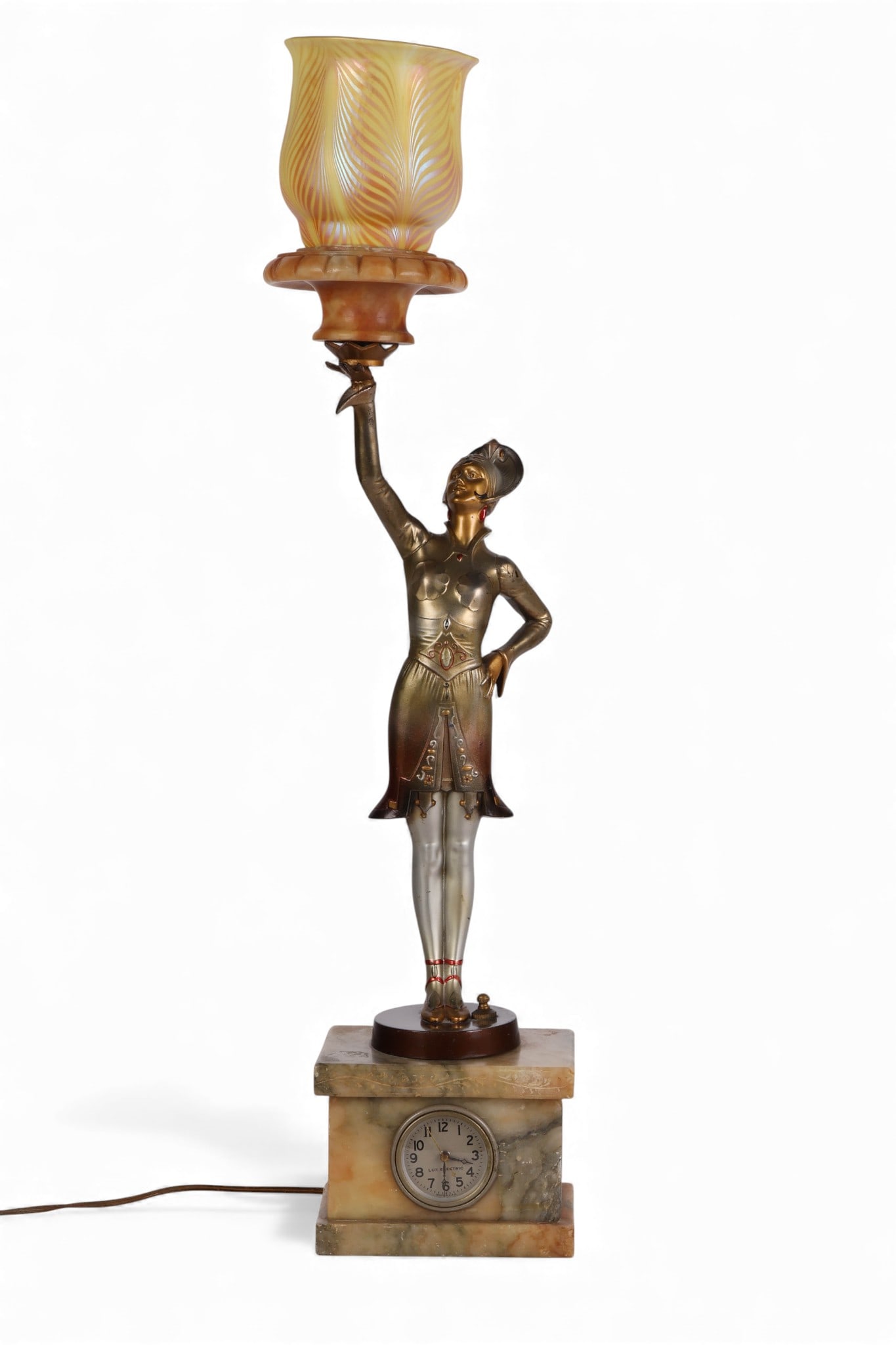 Antique Art Deco German Figural Table Lamp Clock: Art Deco figural lamp clock depicting a standing woman in theatrical costume with feathered headdress, holding an alabaster mount with iridescent glass shade aloft. Crafted in cold-painted and gilt sp
