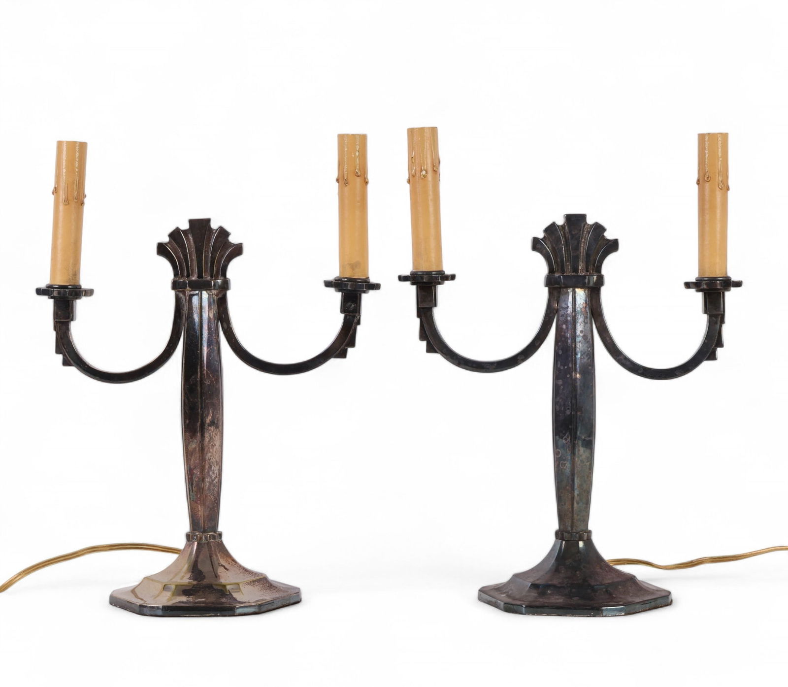 Pair of Vintage Two-Light Candelabra Table Lamps: Pair of vintage electrified candelabra table lamps, each with two scrolling arms terminating in faux candle sockets and mounted on a faceted base. The metal bodies feature a darkened silver-tone finis