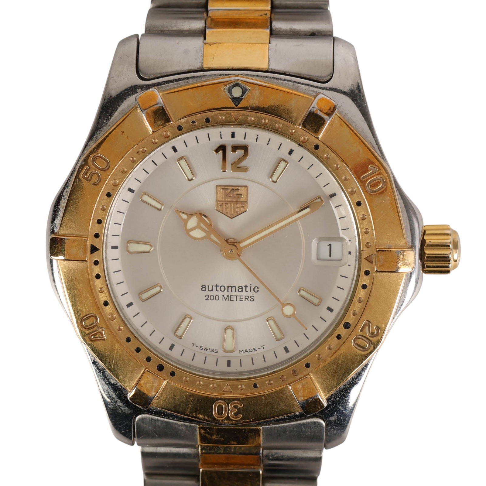 TAG Heuer WK1211 Two Tone Automatic Dive Watch: TAG Heuer, stainless steel and gold-plated automatic wristwatch, model WK1211. This two-tone timepiece features a silver dial with gold tone hands and applied indices, a date window at the 3 o'clock p