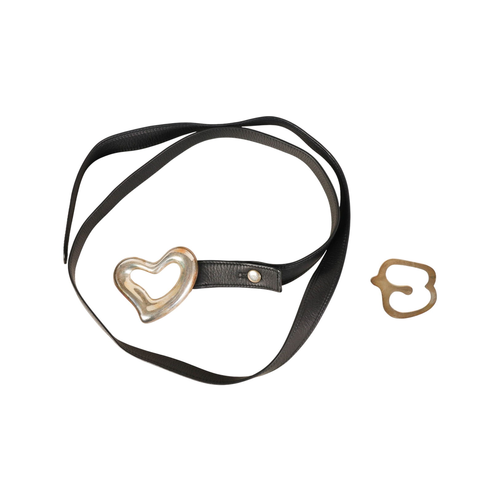Tiffany & Co Sterling Belt Buckle & Book Mark LOT: Tiffany & Company lot of two sterling silver accessories designed by Elsa Peretti, including a heart-form belt buckle with black leather strap and an apple-shaped bookmark. The sculptural heart