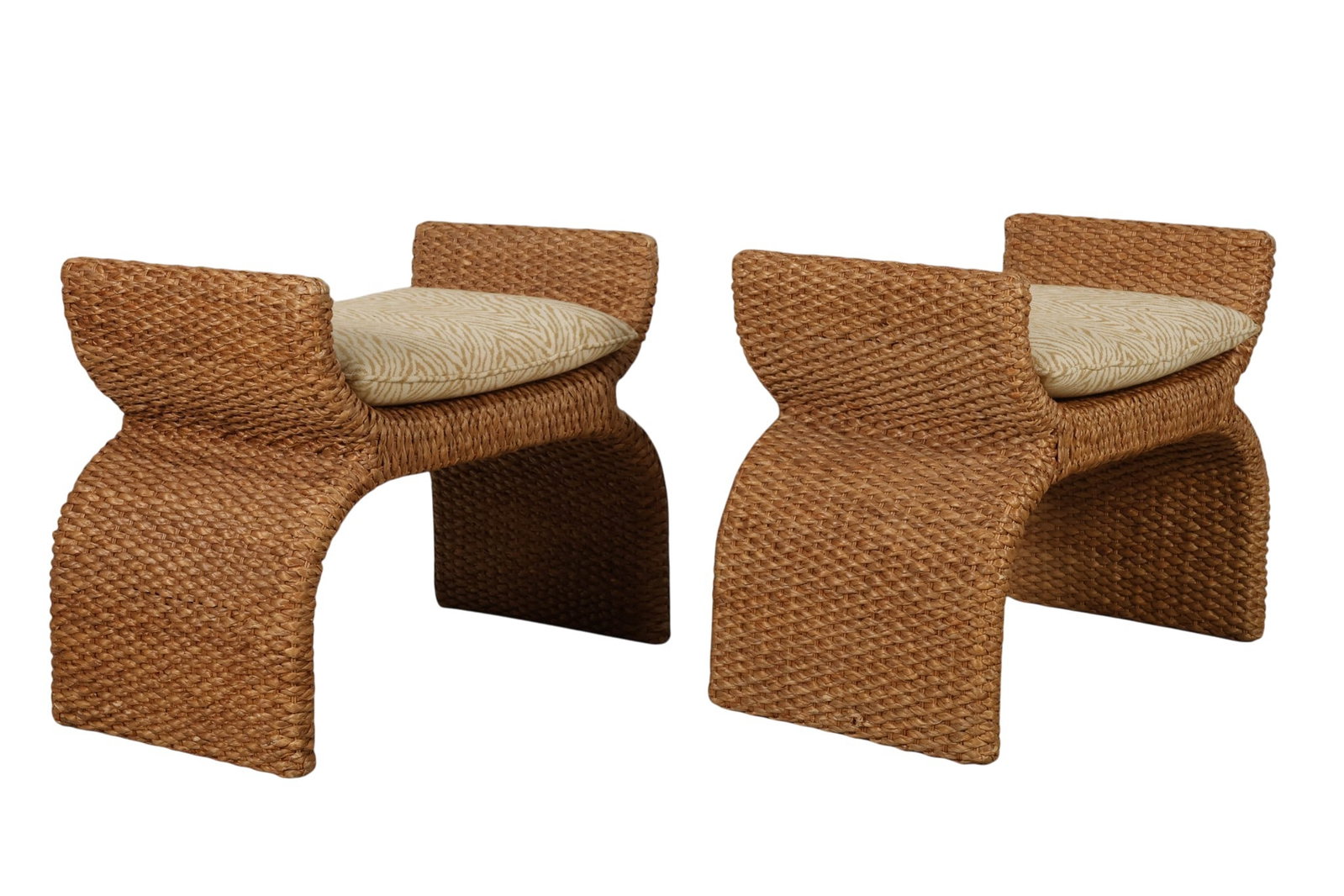 Baker Pair of Milling Road Woven Rattan Benches: Pair of Baker Furniture woven rattan footstools from the Milling Road Collection featuring handwoven natural fiber construction with sculptural curved legs and integrated arm supports. Each stool is t