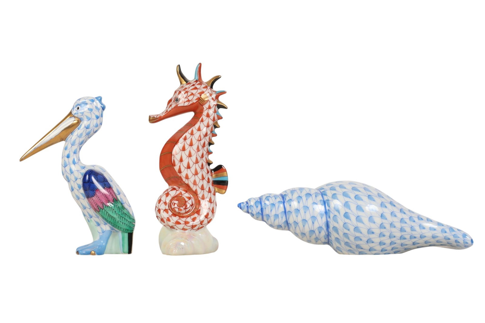 Herend Pelican Seahorse & Shell Fishnet Figurines: Herend Hungary hand-painted porcelain figurines, lot of three. Includes a pelican, a seahorse, and a seashell. Each features the companys signature fish scale decoration in the Blue Fishnet and Rust F