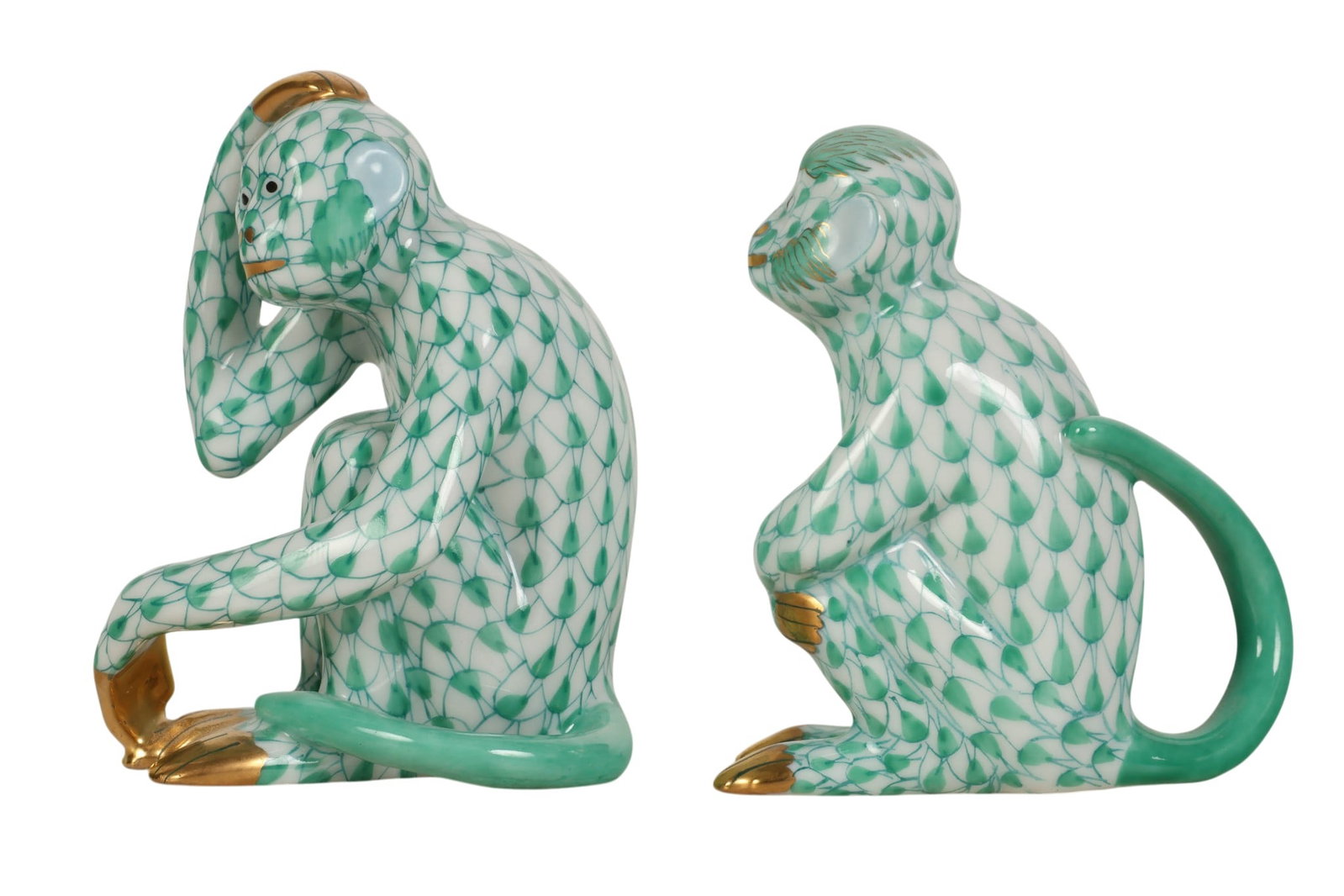 Herend Monkey Green Fishnet Porcelain Figurine LOT: Herend Hungary hand-painted porcelain monkey figurines, two-piece lot. Both feature the companys signature fish scale decoration in the Green Fishnet pattern. Each depicts a seated monkey, with the mo