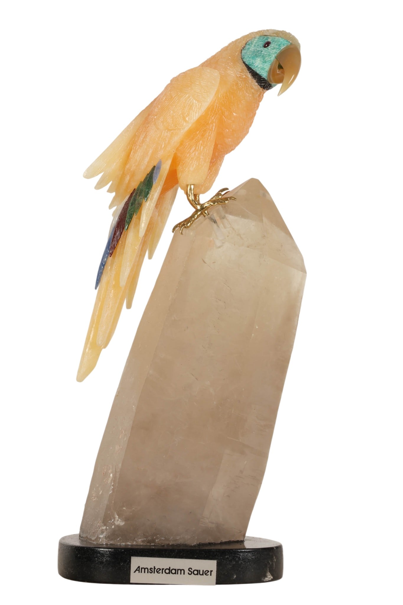 Carved Gemstone Parrot Sculpture on Crystal Base: Brazilian natural mineral hardstone carving of a parrot perched atop a natural quartz crystal point specimen, featuring an orange calcite carved body with multicolored inlaid tail feathers made from s