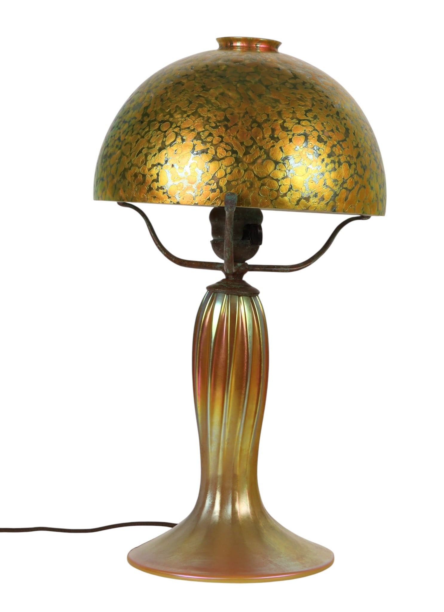 Tiffany Style Iridescent Gold Mottled Shade Lamp: Art Nouveau Tiffany style iridescent art glass table lamp featuring a domed shade with mottled gold and green decoration, supported by a ribbed and flared iridescent glass base. Fitted with a metal th
