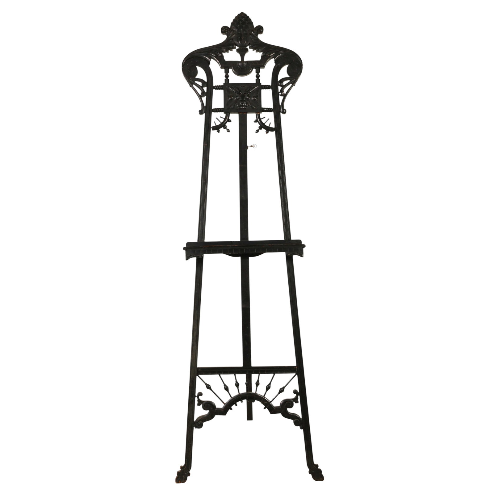 Victorian Gothic Revival Ebonized Wood Floor Easel: Victorian Gothic Revival ebonized wood artist display easel featuring elaborate carved foliate and scrolling decoration surmounted by a prominent pinecone finial. The upper section is centered with a 