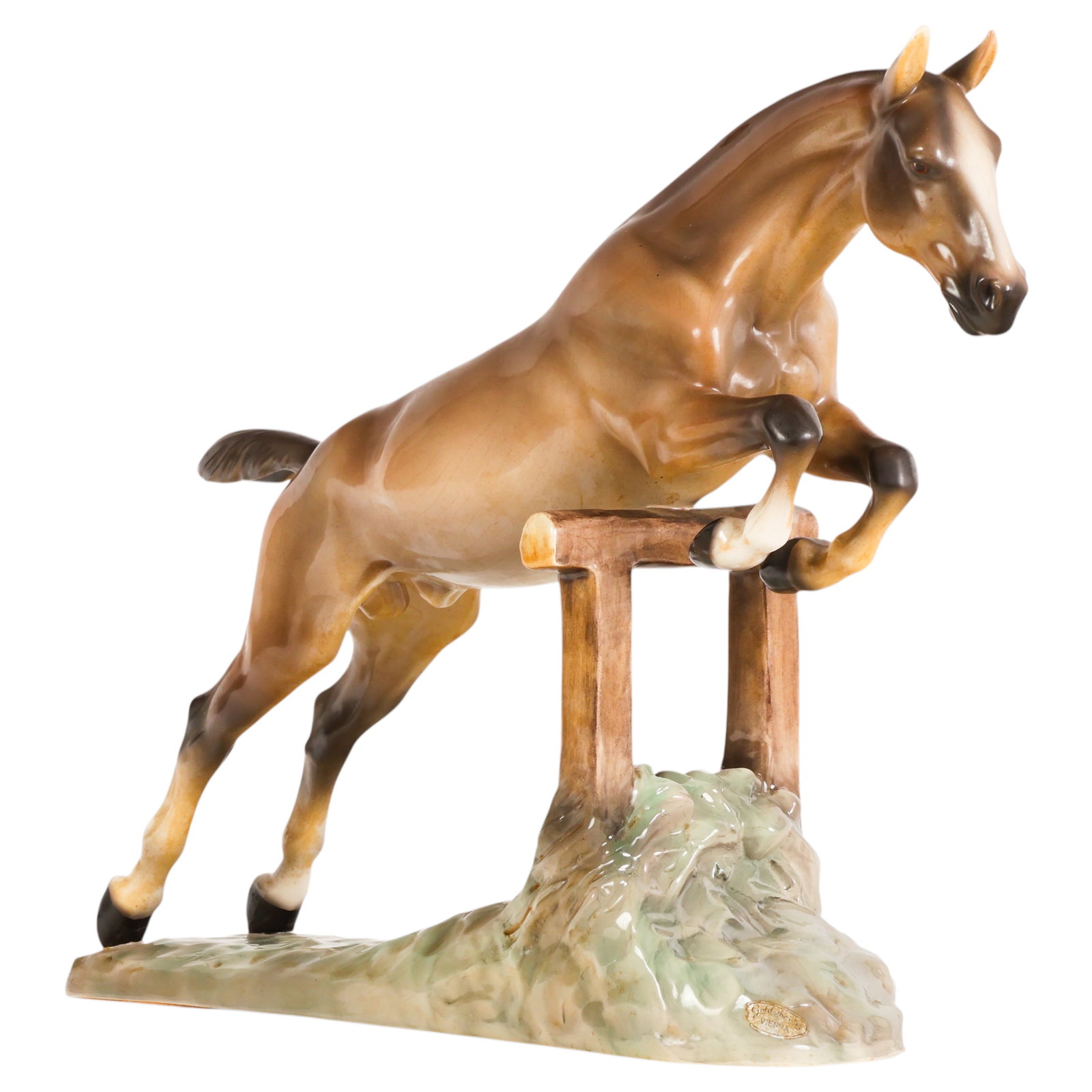Goldscheider Porcelain Jumping Horse Figure SIGNED: Goldscheider Wien Austrian porcelain jumping horse figure depicting a brown horse clearing a jump, modeled in mid-leap over a fence and textured base. Underside with impressed and printed Goldscheider