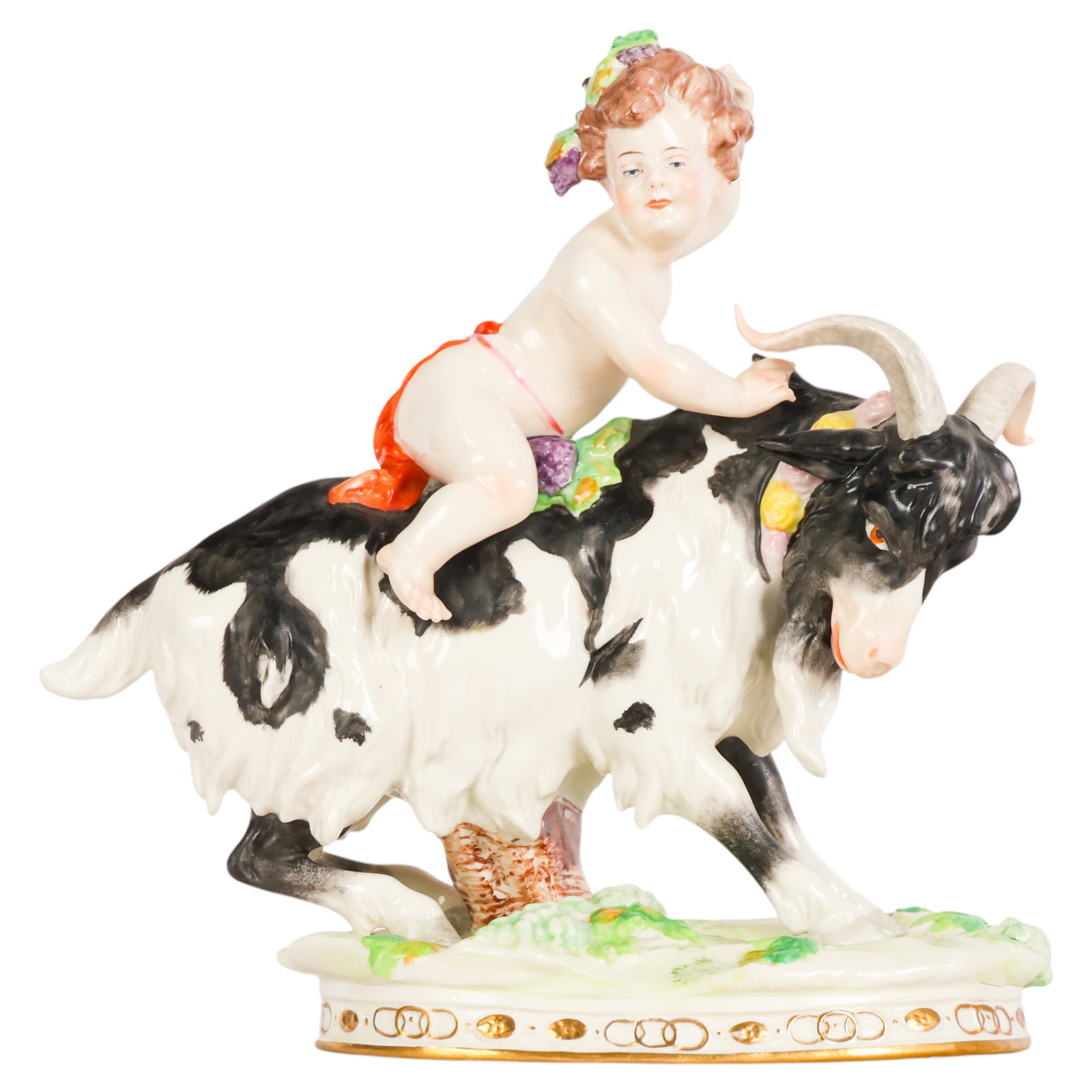 Scheibe-Alsbach German Porcelain Cherub Figurine: Antique Scheibe-Alsbach German porcelain figural group depicting a cherub or putto seated atop a black and white goat adorned with floral garlands and grapevine motifs. The hand-painted figure feature