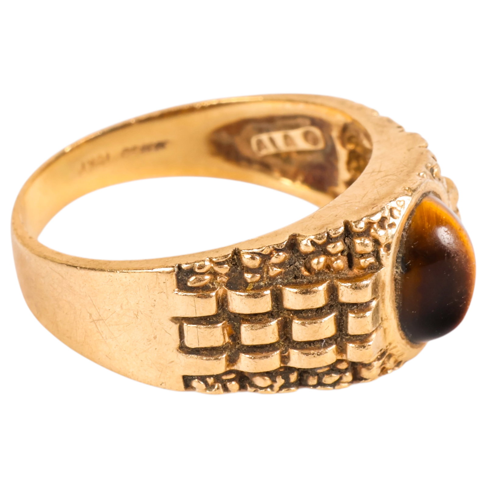 10KP Gold Vintage 1970's Catseye Ring 6 Grams: Vintage 1970s 10KP gold ring featuring a woven design band set with a cat's eye stone. Marked inside the band "10KP," "ALA," and four additional initials that are not fully legible. Ring size 9. Total