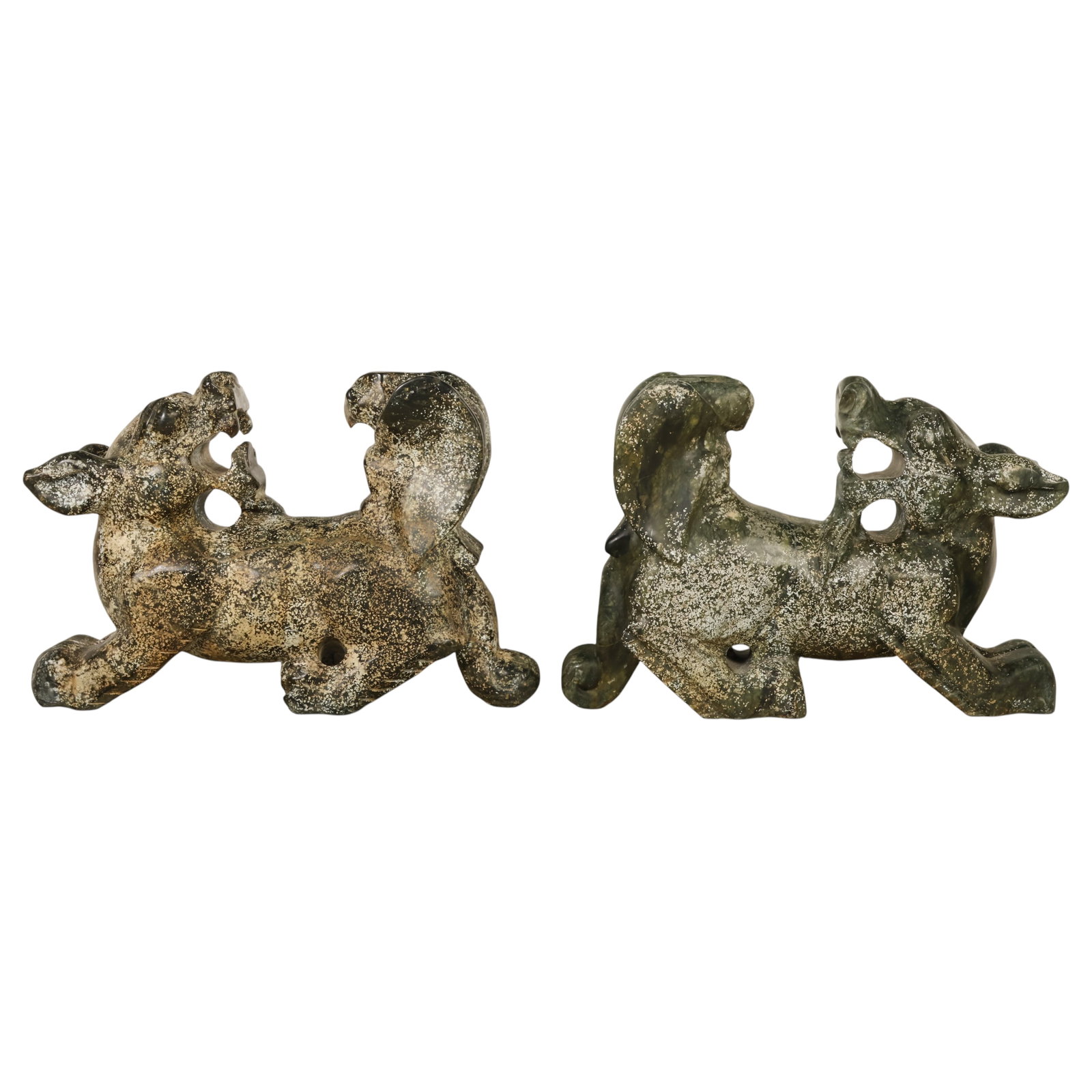 Chinese Pair of Carved Green Hardstone Dragons: Pair of Chinese style carved dark green hardstone dragon sculptures, featuring high relief with sinuous dragon forms emerging from pierced, naturalistic openwork stone. The mottled green and black