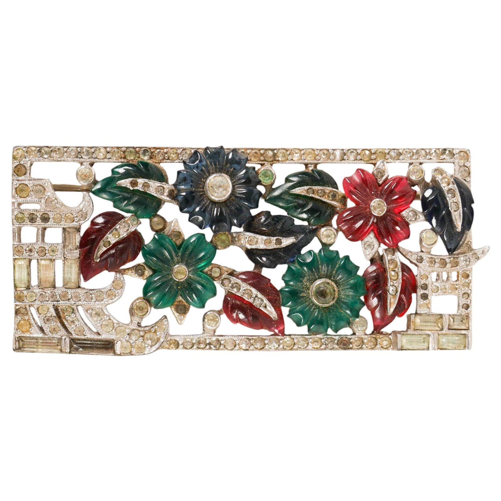Art Deco Tutti Frutti Rhinestone Floral Brooch Pin: Art Deco-style "Tutti Frutti" floral brooch of rectangular openwork form, set with carved flower and leaf elements in deep green, ruby red, and dark blue tones, accented throughout with clear rhinesto