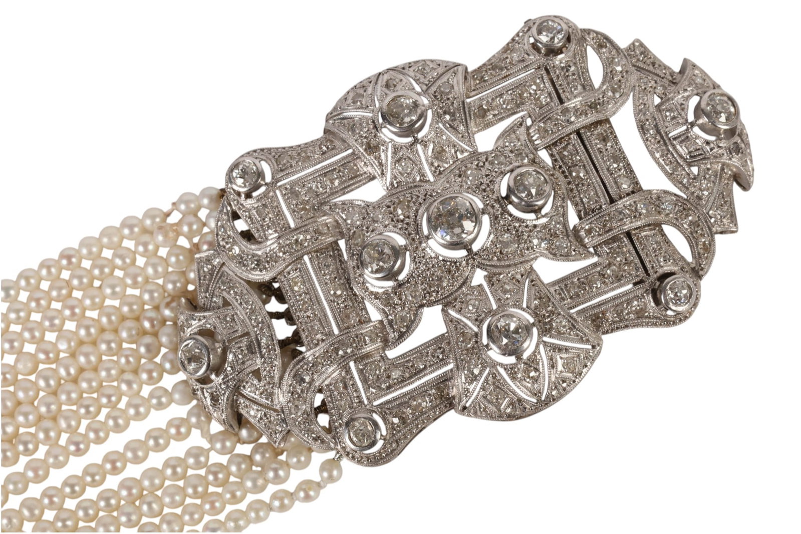 Multi Strand Art Deco Diamond Clasp Pearl Necklace: Art Deco platinum and diamond thirteen-strand pearl necklace, composed of approximately 3 mm cream-white seed pearls and centered by an impressive geometric openwork platinum plaque clasp set with ele