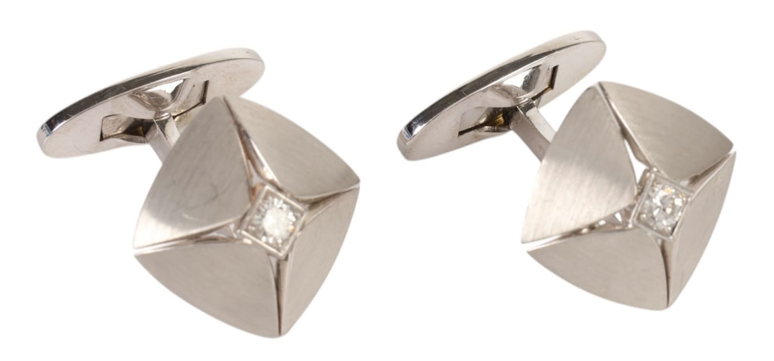 Pair of 18K White Gold Diamond Modernist Cufflinks: 18K white gold, a pair of cuff links featuring a bold geometric design with brushed and high polish finishes. Each cuff link is centered with a round brilliant cut diamond set within a square bezel, w