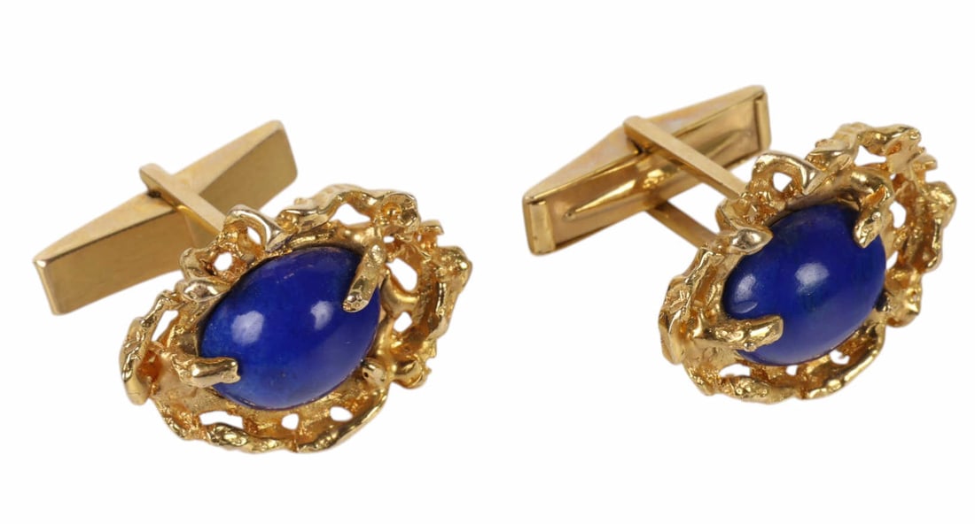 Pair of 14k Yellow Gold and Lapis Lazuli Cuff Link: 14K yellow gold, a pair of cuff links set with oval lapis lazuli cabochons measuring approximately 11 x 9 mm each. The richly saturated blue lapis stones are bezel set within organic sculptural gold s