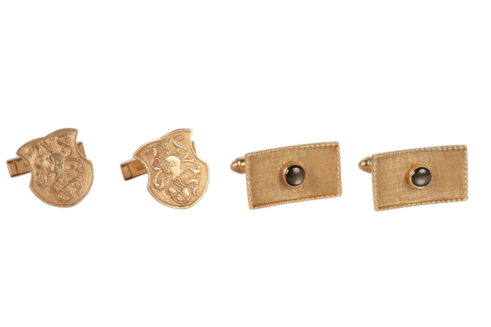 14k Gold Repousse & Sapphire Cufflinks 2 Pairs LOT: 14K yellow gold, a lot of two pairs of cuff links. The first pair features a shield form design with repousse coat of arms motif showcasing scrolling foliate elements and a heraldic crest in textured