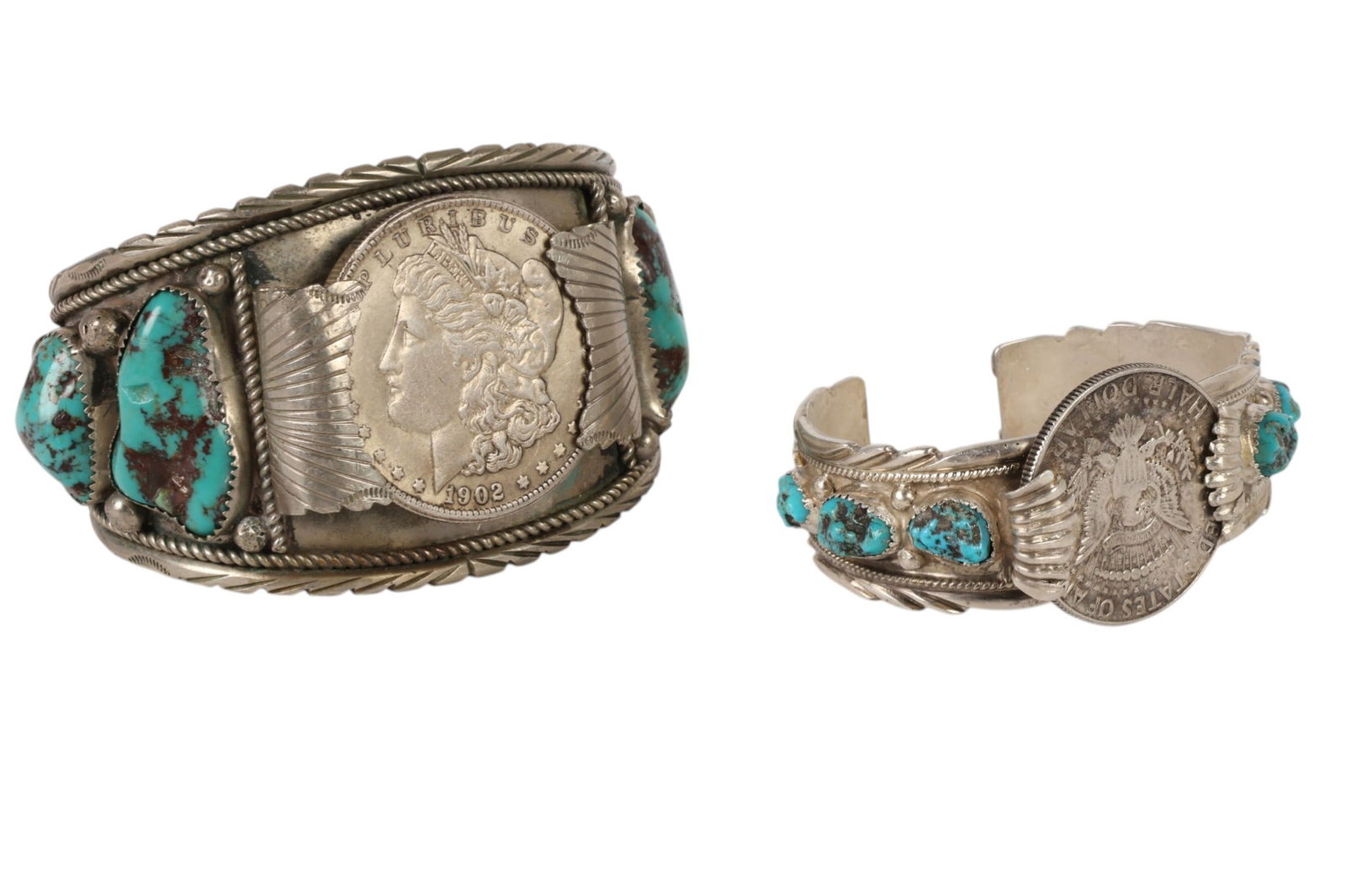 Two Sterling Native American Coin Cuff Bracelets: Lot of two Native American coin silver cuff bracelets set with turquoise nuggets and mounted with United States silver dollar coins dated 1902. The larger cuff features a prominent Morgan silver dolla