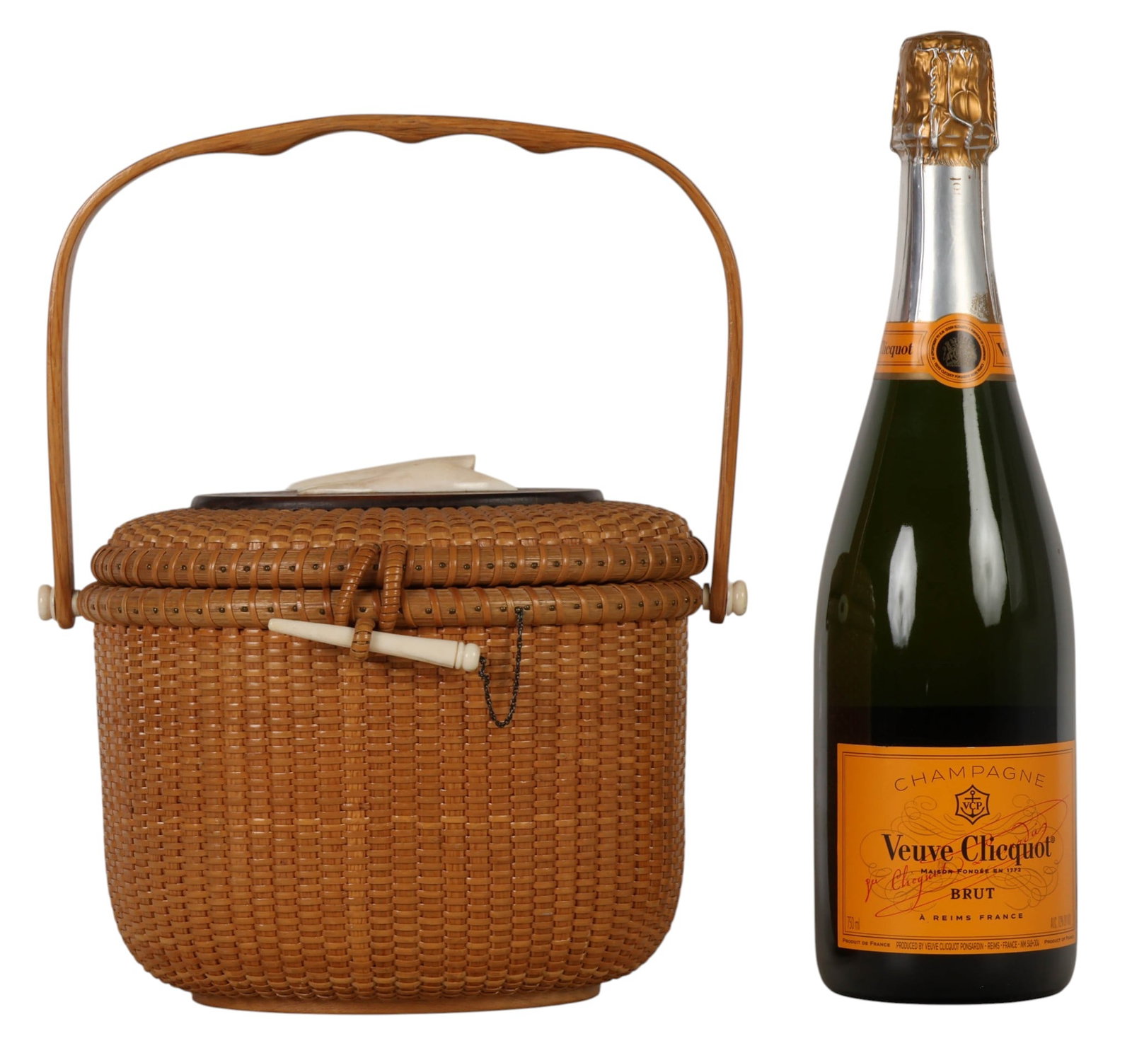 Nantucket Hand Woven Rattan & Cane Storage Basket: Nantucket, an American folk art hand woven rattan and cane basket featuring a swing handle, carved bird finial mounted to a wood lid, and scrimshaw style peg closure. Interior open cavity for storage.