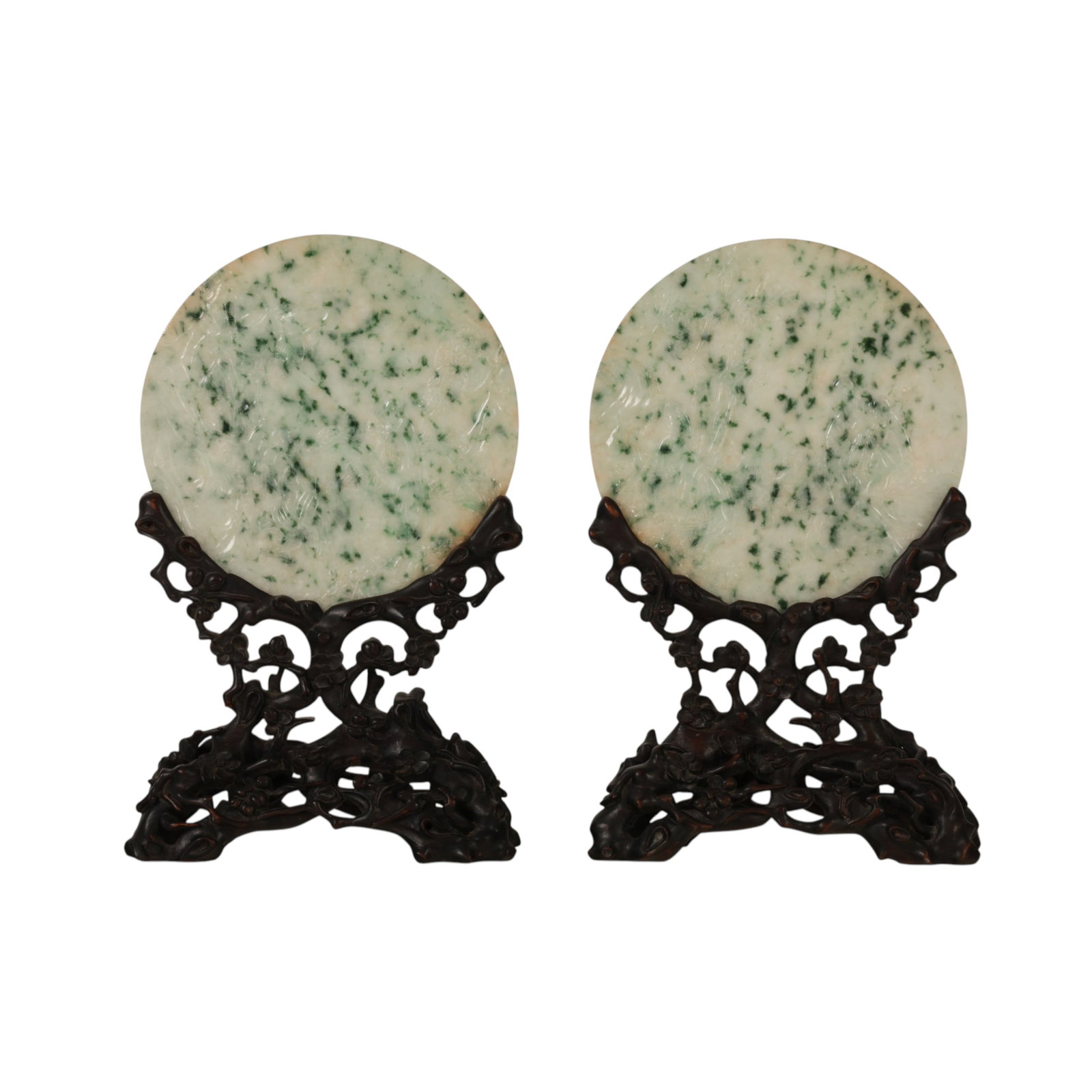 Chinese Pr Carved Jade Figural Floral Desk Screens: A pair of Chinese hand carved green jade table top screens. Each circular disk panel decorated with raised relief carvings of floral, bird, and figural designs. Both exhibit natural translucency and v