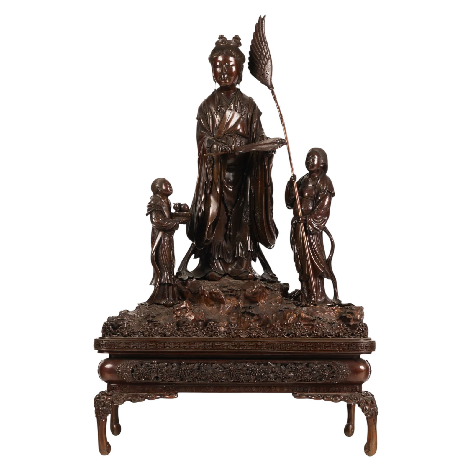 Japanese Bronze Goddess Figural Group Sculpture: Japanese Meiji period, a bronze figural group depicting a standing bodhisattva accompanied by two attendants, each holding symbolic objects, all positioned upon a naturalistic rocky base. The central