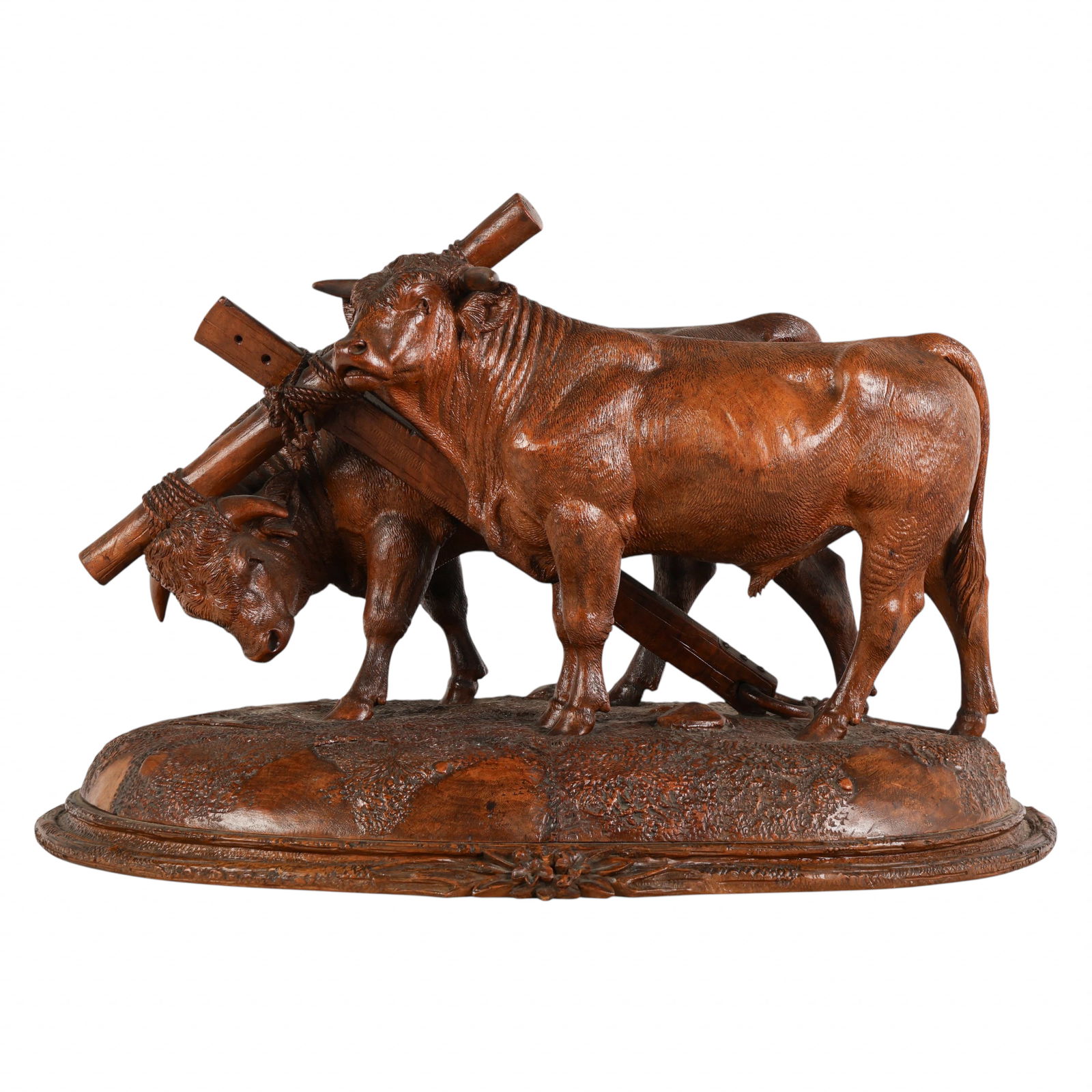 Swiss Black Forest Large Wood Yoked Oxen Sculpture: Attributed to Johann Huggler (Swiss, 1834-1912), a carved Black Forest wood figural sculpture depicting two yoked oxen standing side by side upon a naturalistic textured base adorned with floral and