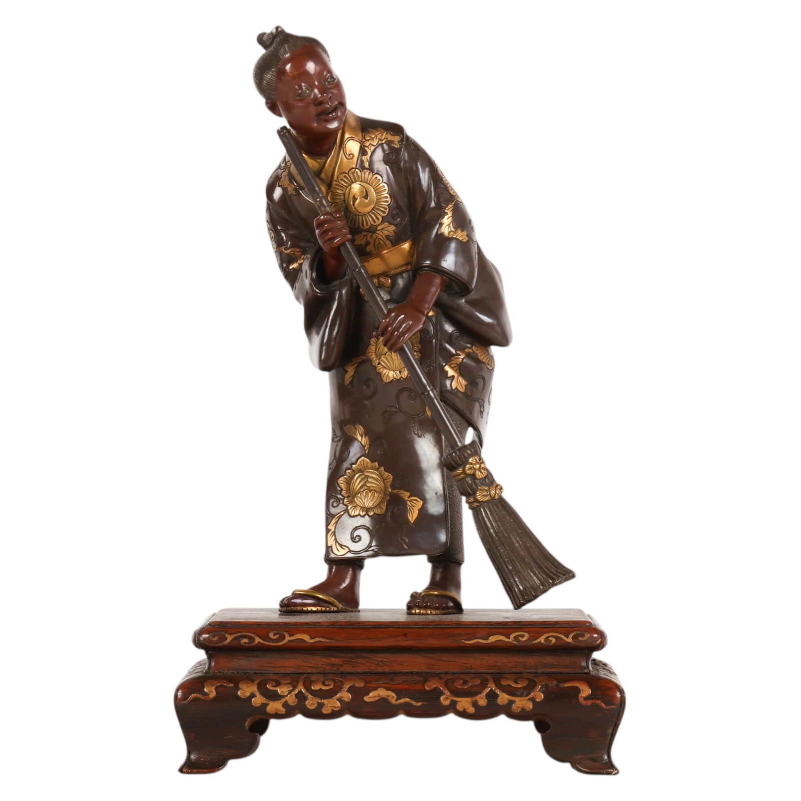 Japanese Miyao Bronze Okimono Broom Man Sculpture: Japanese, Meiji period Miyao bronze okimono depicting a standing youth holding a broom dressed in traditional attire with applied gilt floral decoration throughout the garment. Mounted on a carved